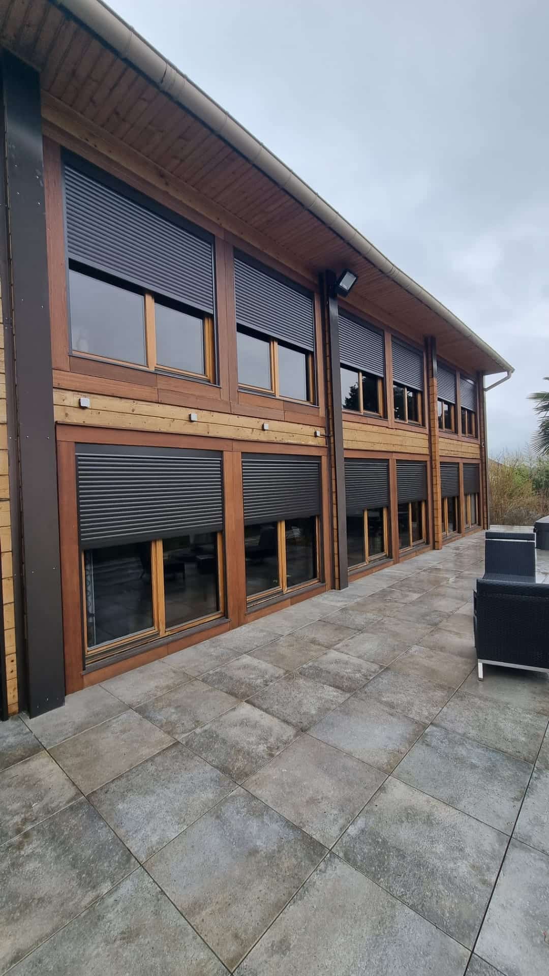 Façade à bardage bois équipée de volets roulants aluminium anthracite, dans le secteur de Metz